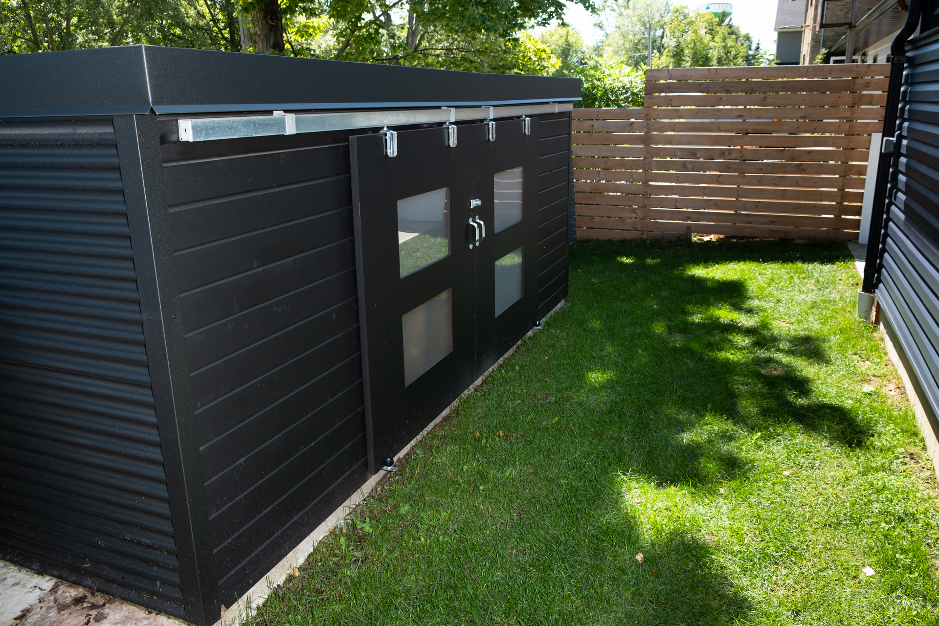 Custom double sliding barn doors with frosted Lexan glass windows on a 15x5 Cube Shed in Lucan Ontario, installed by Backyard Escape Studios.
