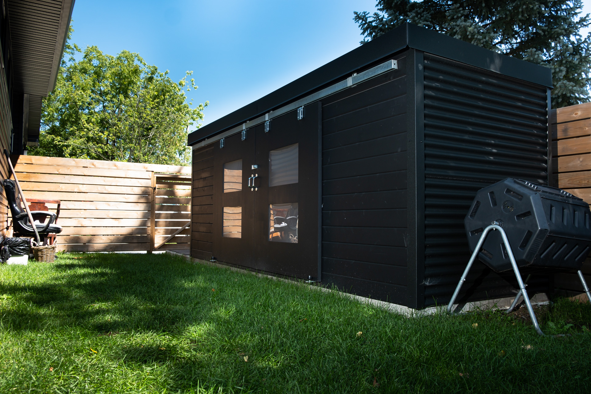 Side view of 15x5 Cube Shed with Jet Black corrugated steel siding and EPDM flat roof in a Lucan Ontario backyard, installed by Backyard Escape Studios.