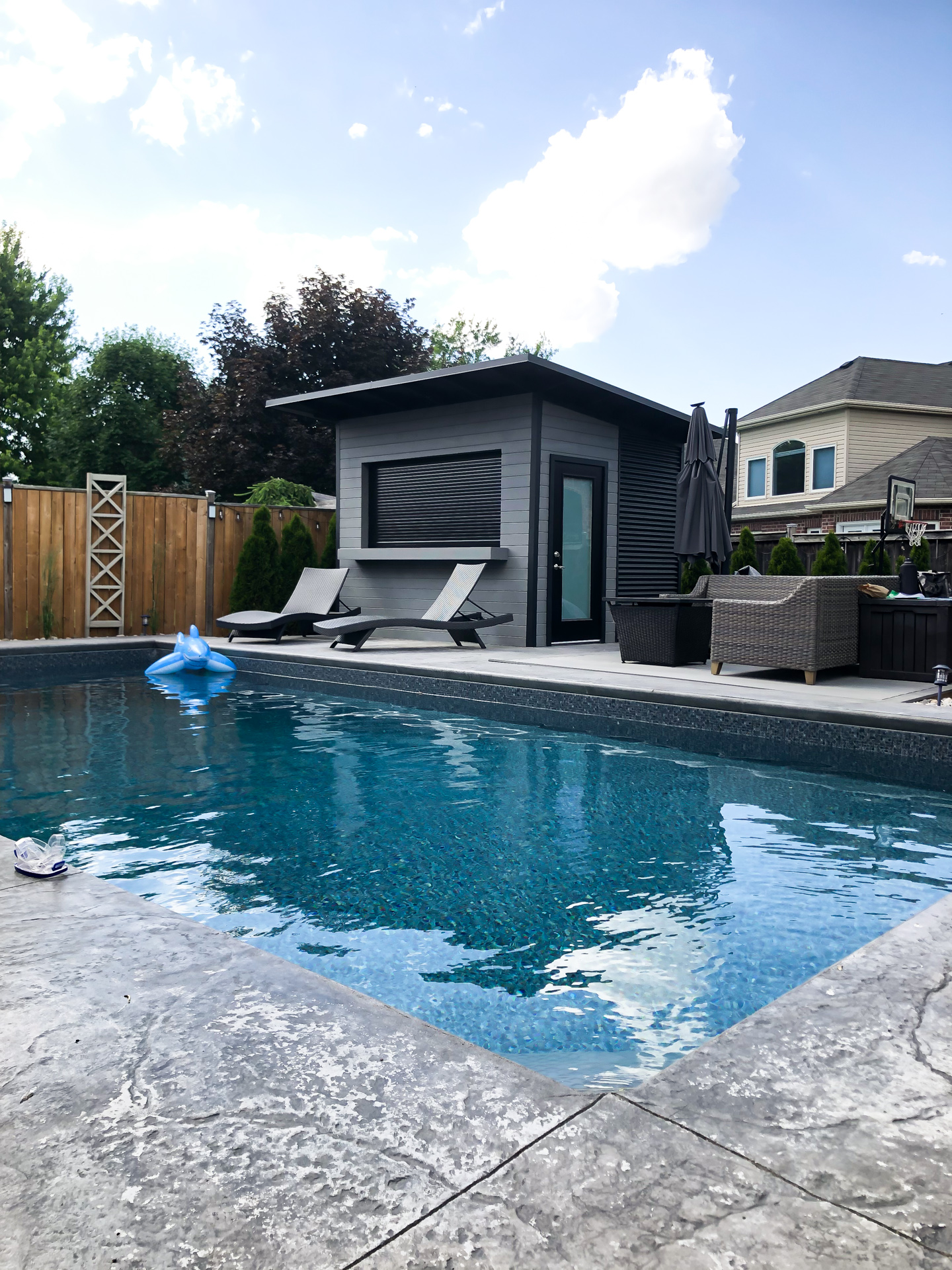 11x9.5 Advanced Shed pool shed with Kendall Charcoal pine siding and Jet Black corrugated steel on pool deck in London Ontario, installed by Backyard Escape Studios.