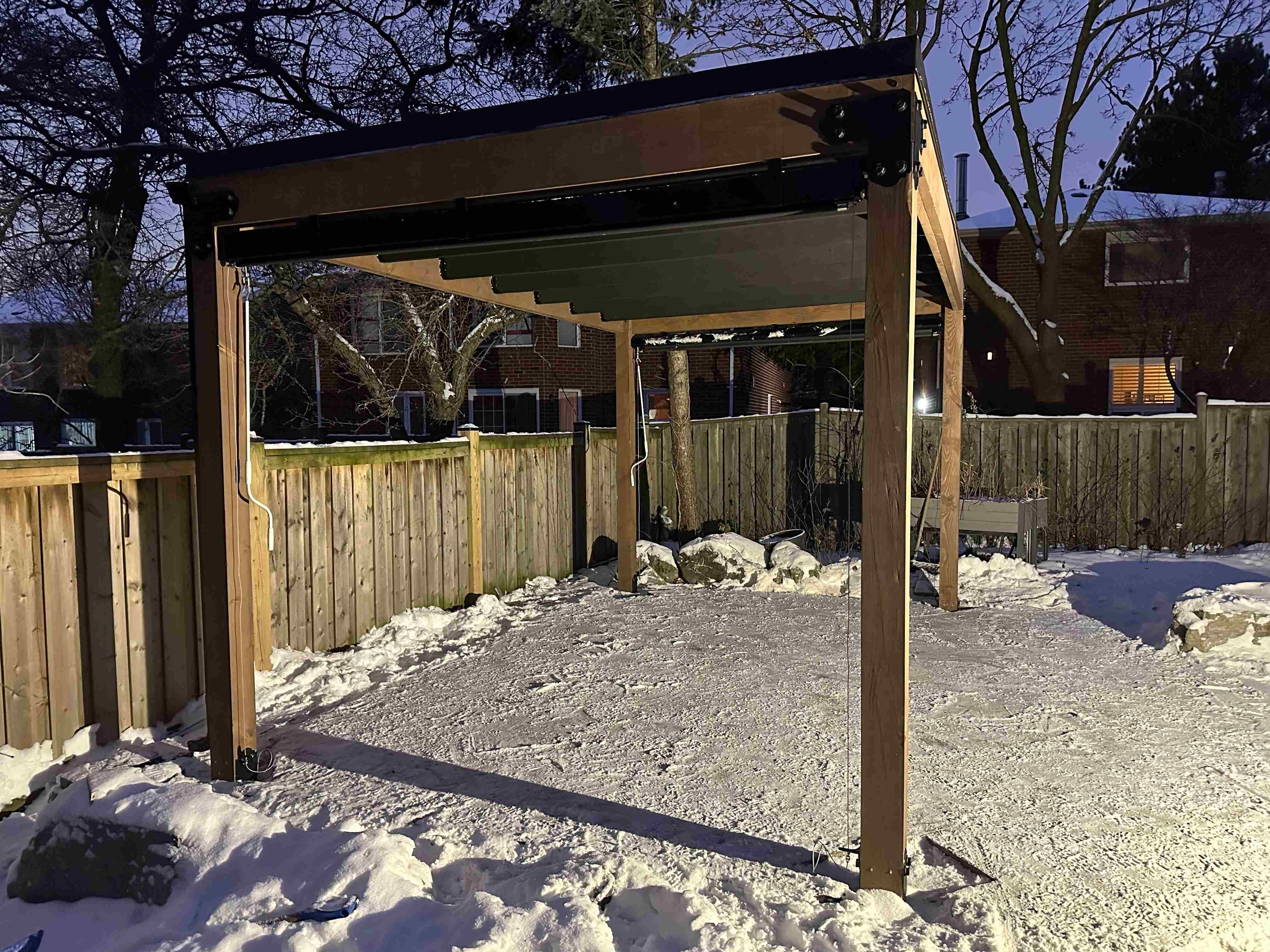 16x10 pergola in Markham Ontario with Apollo cable-drop screens fully deployed, glowing warm at night, installed by Backyard Escape Studios.
