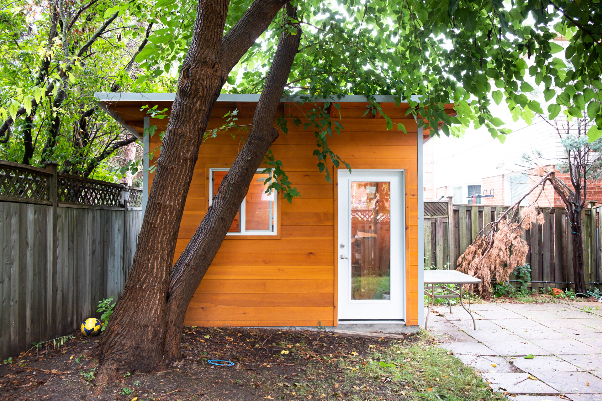 Cedar backyard studio with glass door installed in a mature-treed Vaughan Ontario backyard