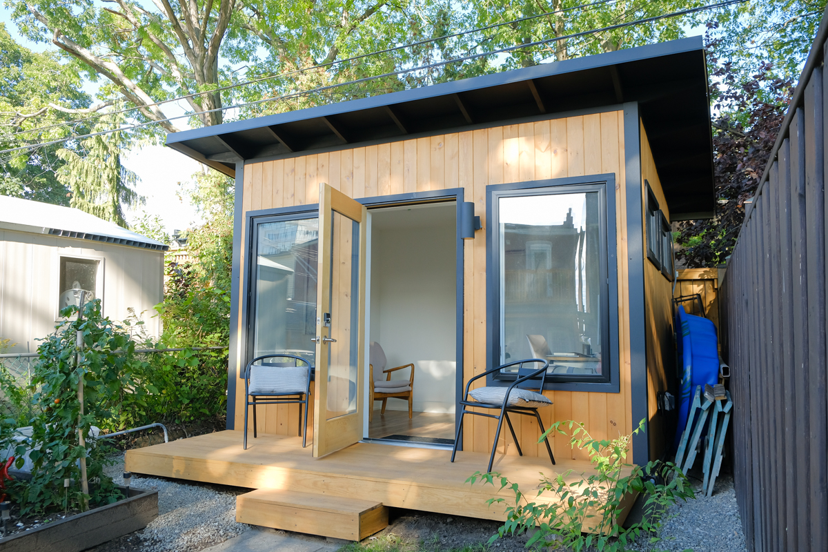 12x9 Backyard Office Studio with cedar tongue and groove siding, dark trim, outswing glazed door, and front deck in Toronto Ontario, built by Backyard Escape Studios.