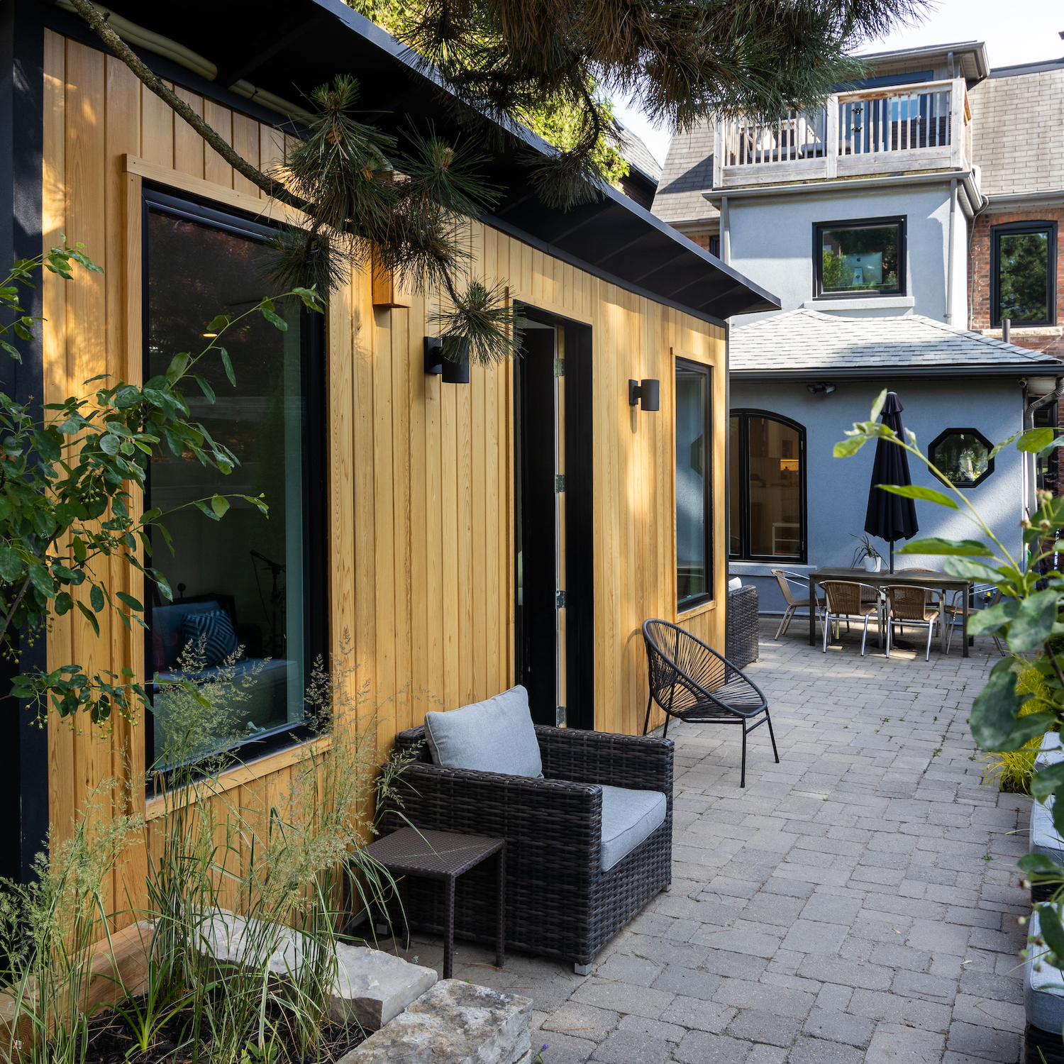 Premium aluminum doors and black porch lights on a custom cedar backyard studio in Toronto, Ontario by Backyard Escape Studios