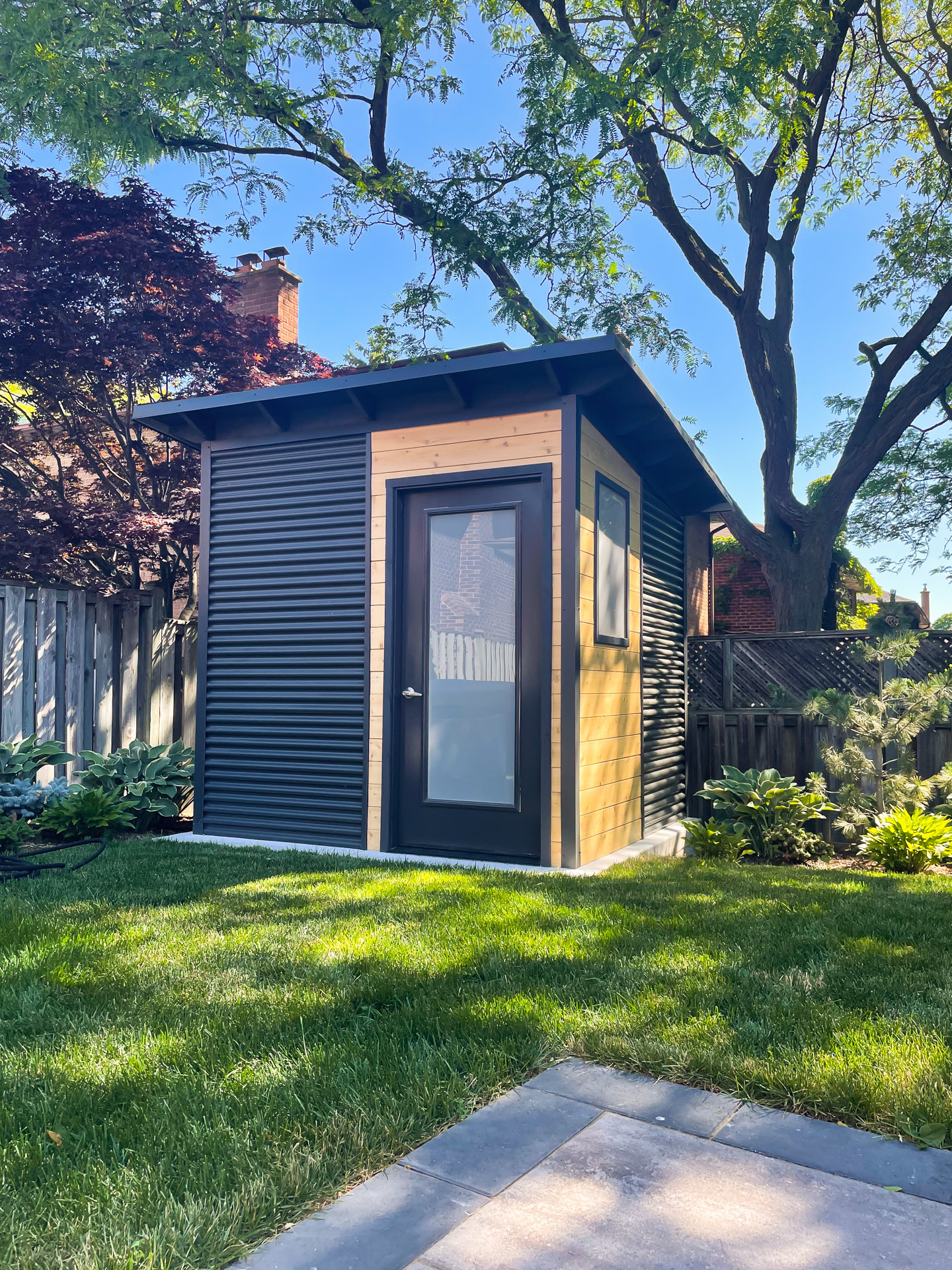 Frosted glass inswing door on an 8x8 Garden Shed in Etobicoke Ontario, framed by Eastern White Cedar in an Essential Shed by Backyard Escape Studios.