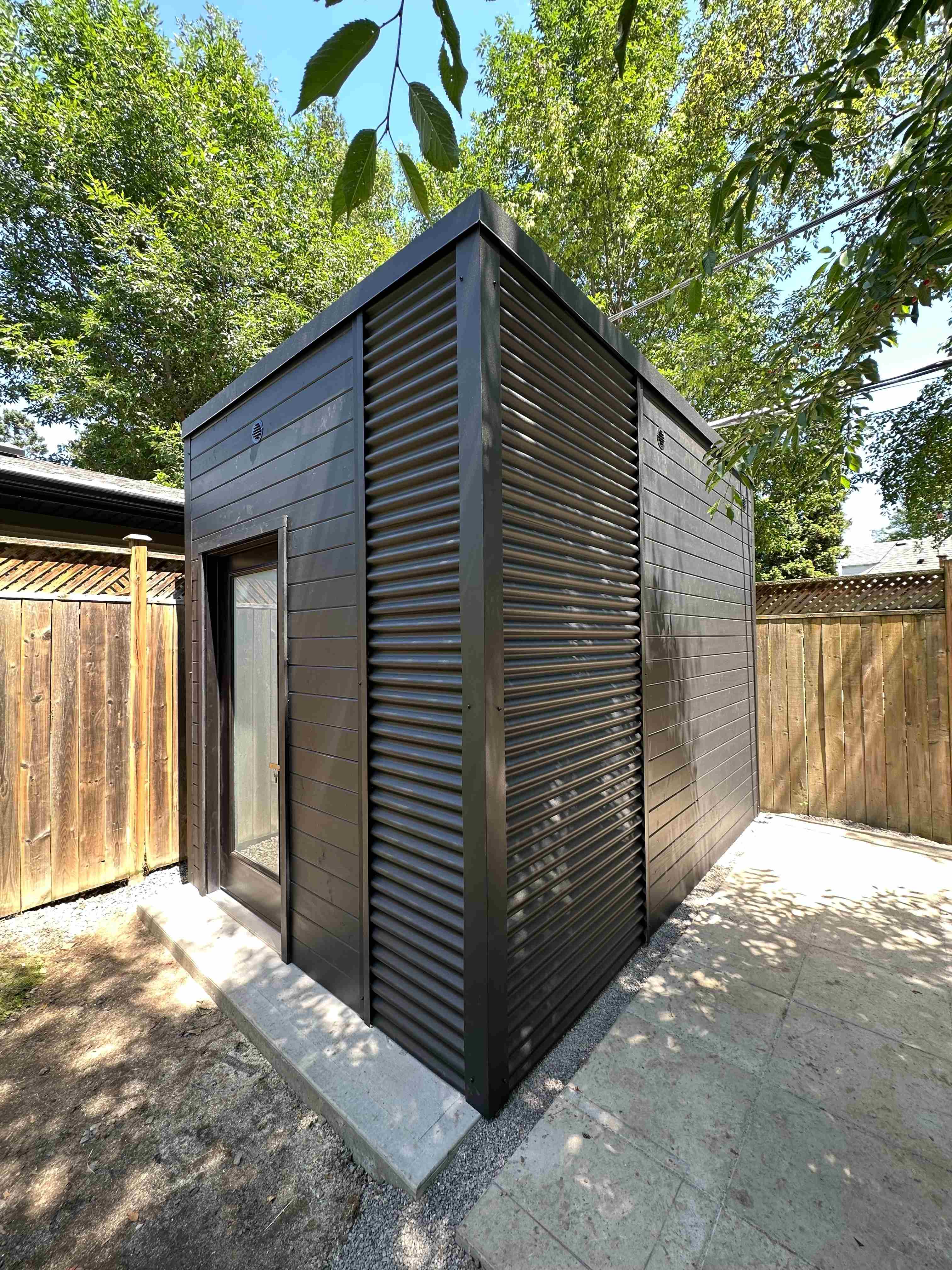 8x12 Cube Shed modern shed with black pine siding and steel accent corner in Etobicoke, Ontario.