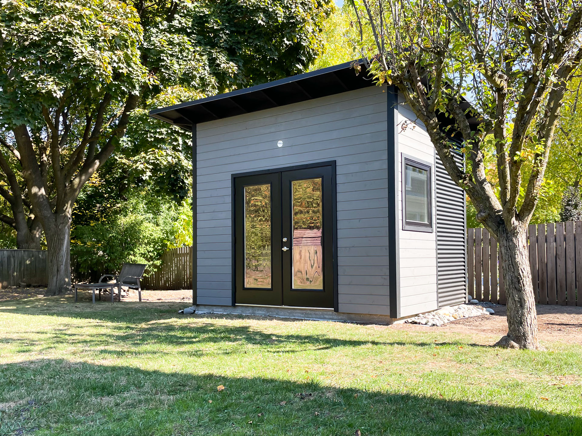 12x9 Backyard Studio with Jet Black corrugated steel siding and Kendall Charcoal stained pine in Oakville, Ontario, installed by Backyard Escape Studios.