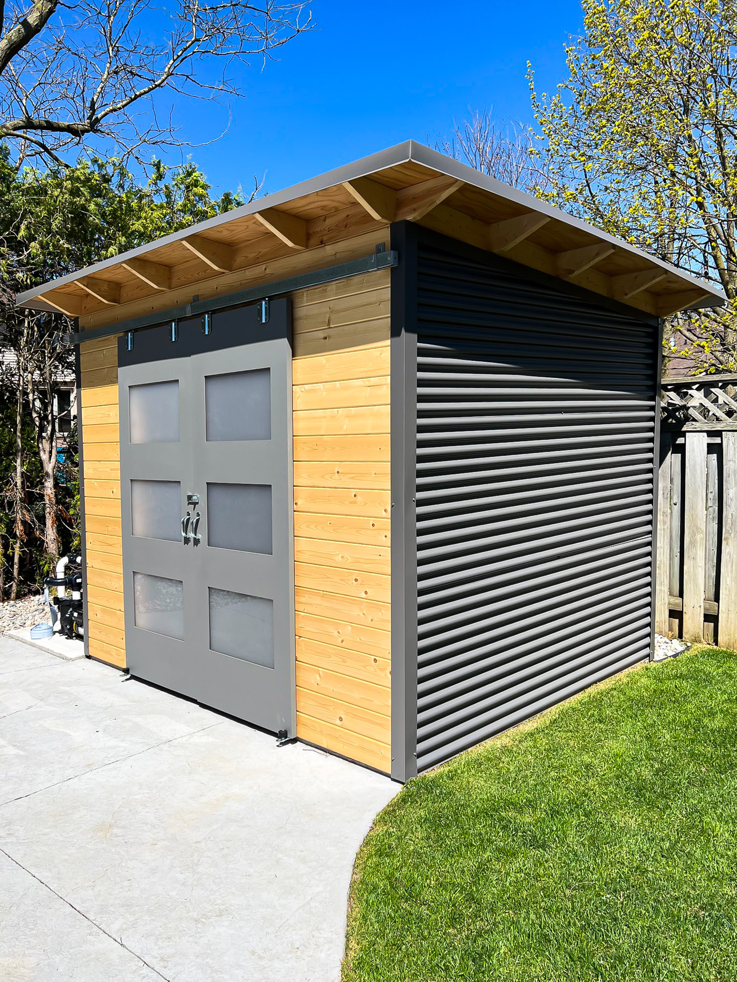 10x8 Pool Shed with charcoal corrugated steel siding and clear coat pine, Essential Shed installed in London, Ontario.