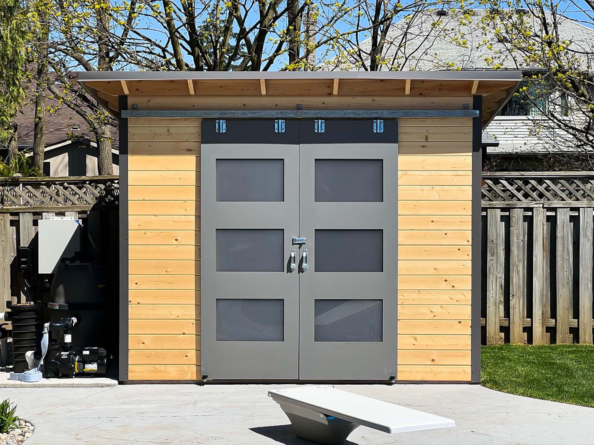 Double sliding barn doors with frosted glass on a 10x8 Pool Shed, Essential Shed installed in London, Ontario.