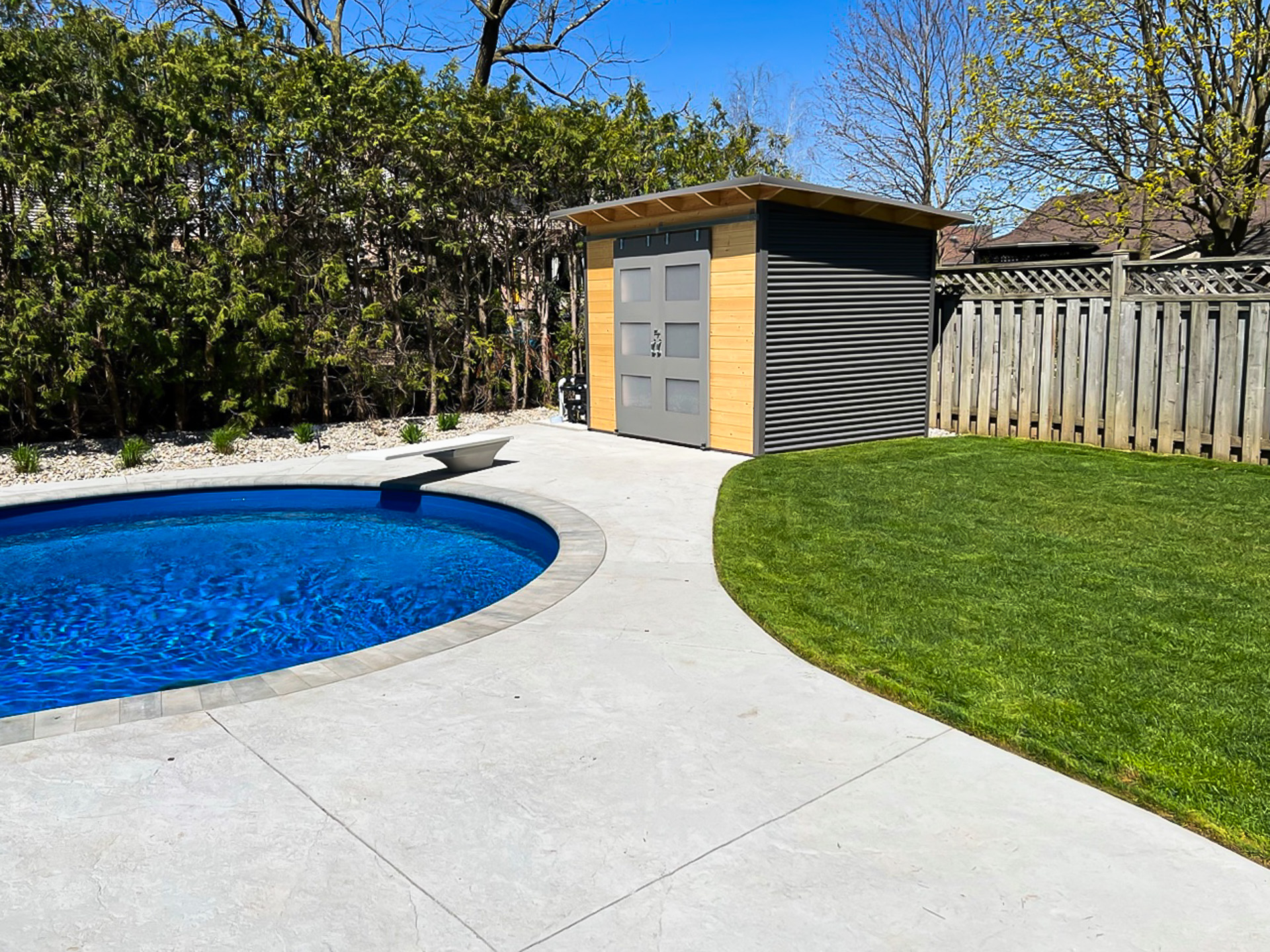 10x8 Pool Shed in a London, Ontario backyard, Essential Shed with charcoal steel and clear coat pine finish.