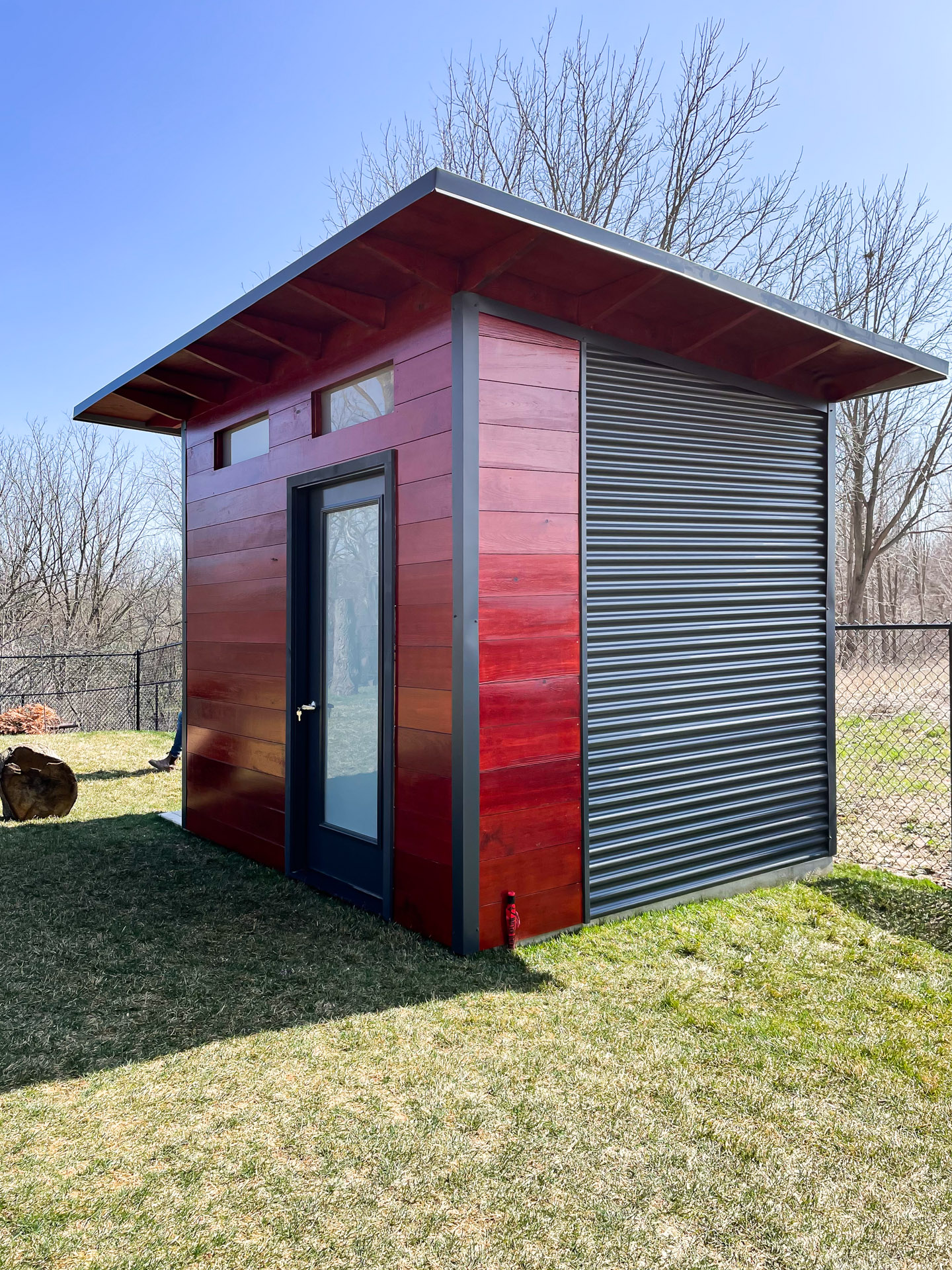 10x8 Advanced Shed styled as a modern shed with mahogany-stained pine siding and Iron Ore steel accents in Belmont, Ontario, installed by Backyard Escape Studios