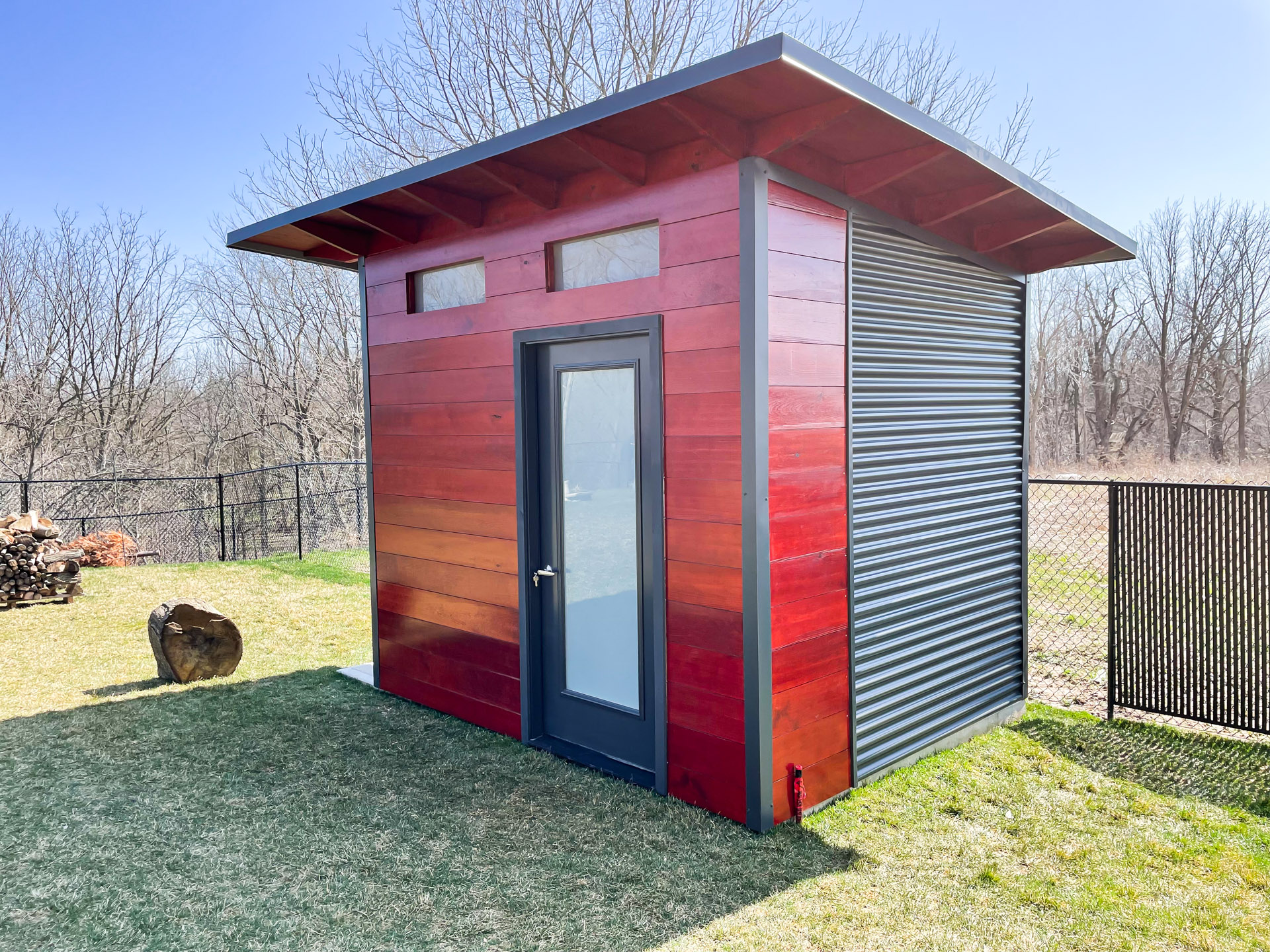 Advanced Shed modern shed in Belmont, Ontario with Black Beauty stained glass-insert door and transom windows above the entrance