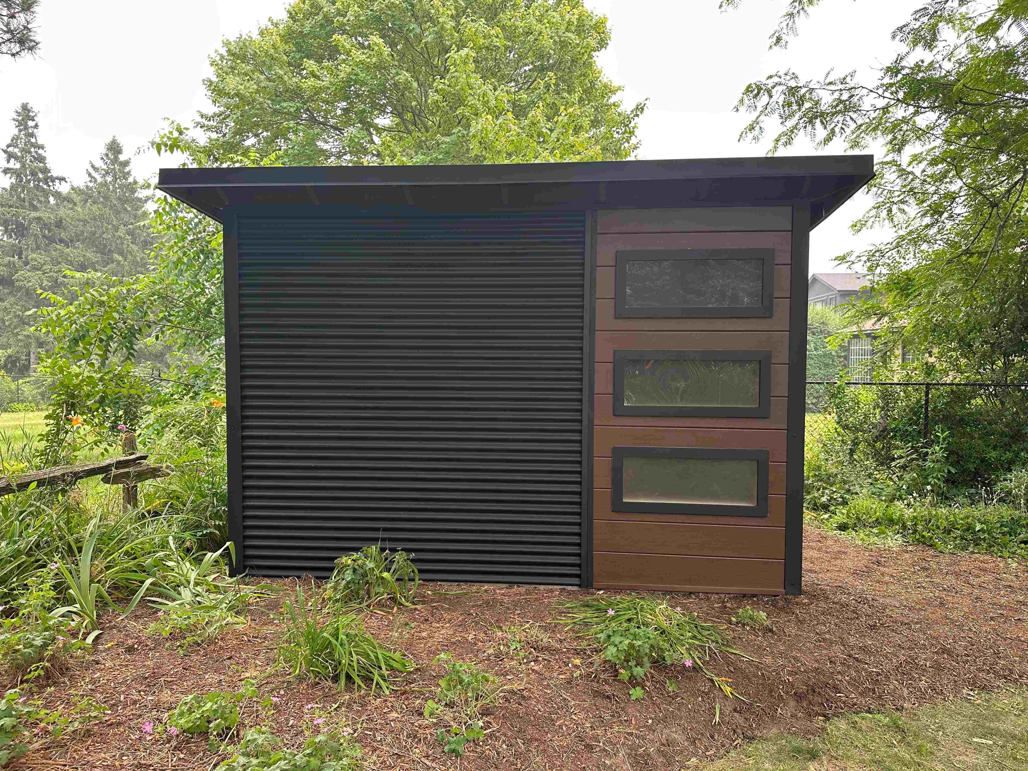 Side view of a 12x10 modern shed in Waterloo, Ontario, showing Jet Black corrugated steel siding and skillion roofline.