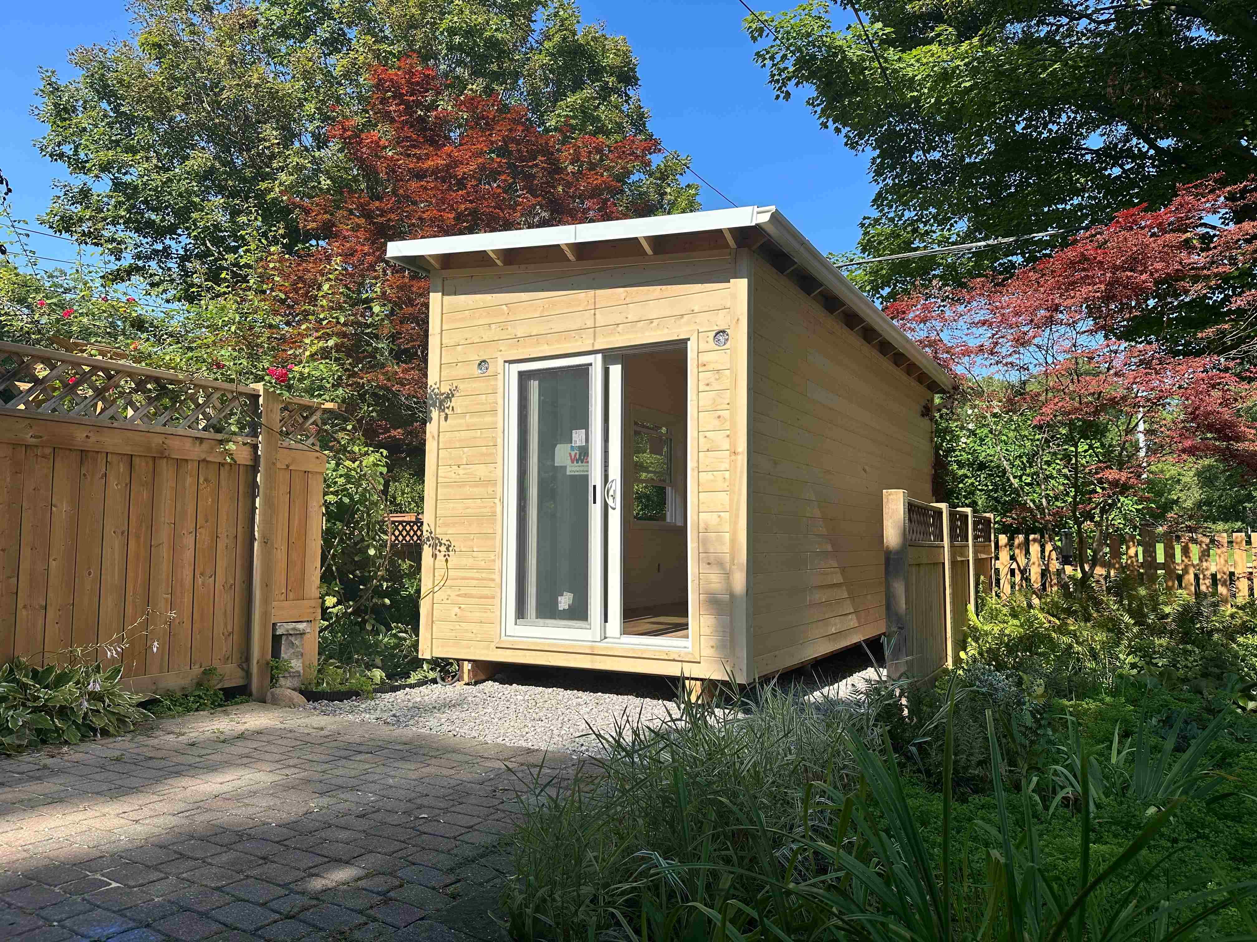 20x8 Backyard Office studio with pine tongue-and-groove siding and a white sliding glass door in Toronto, Ontario, installed by Backyard Escape Studios.