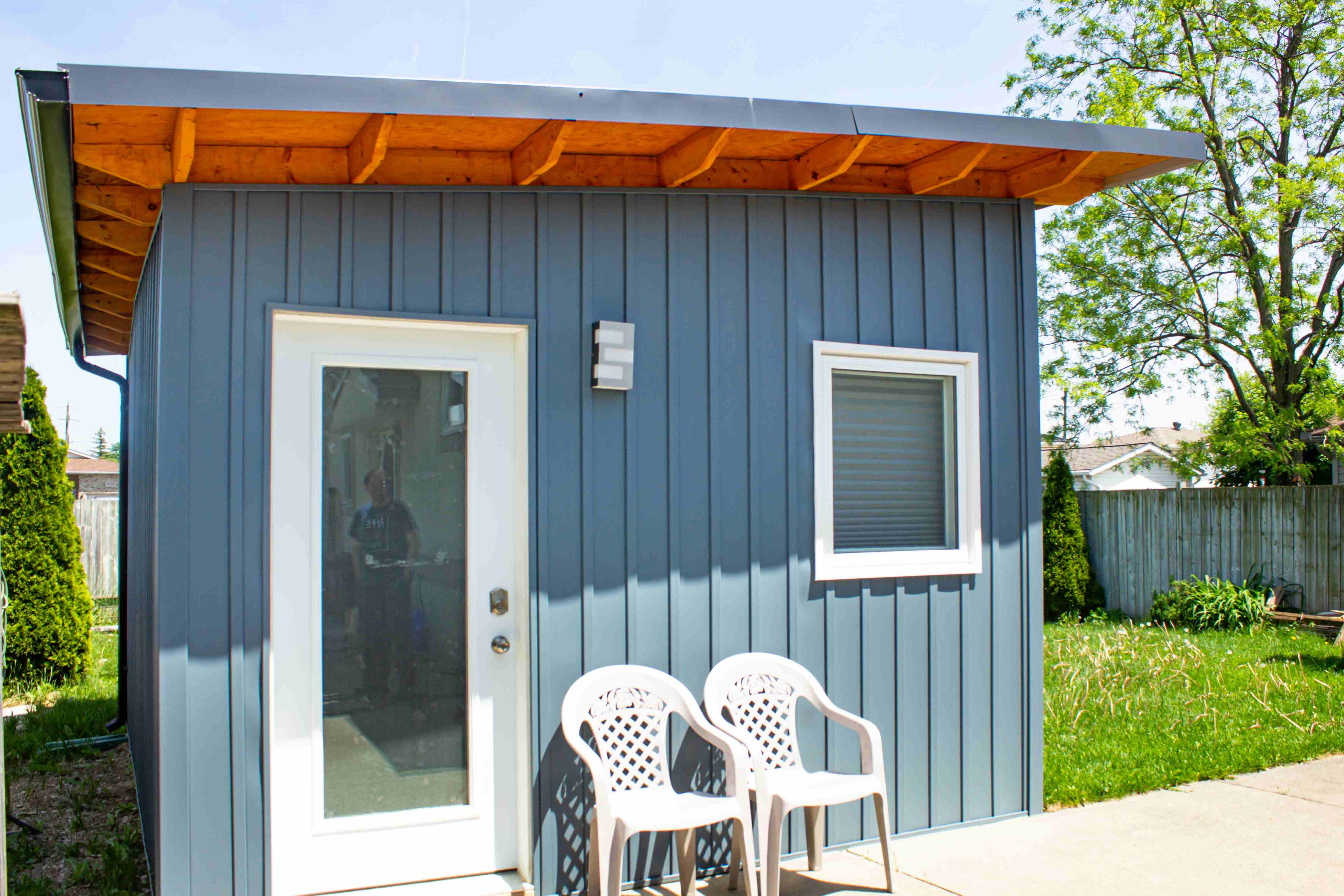 16x12 Music Studio exterior with slate blue vertical steel siding and natural wood soffit accent in Windsor, Ontario, installed by Backyard Escape Studios.