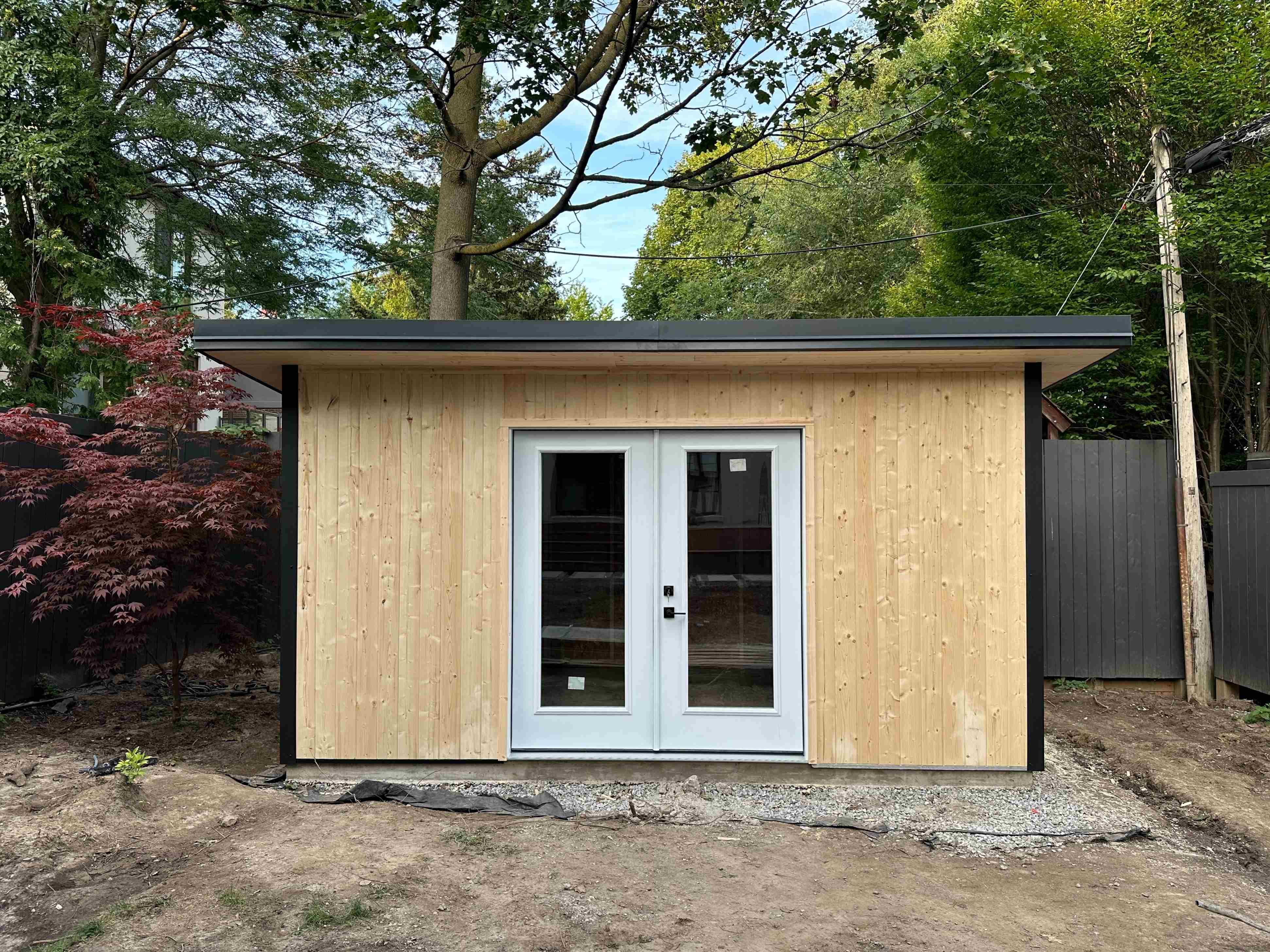 15x10 Essential Shed with natural pine siding and black Ebony trim in Toronto, Ontario, installed by Backyard Escape Studios