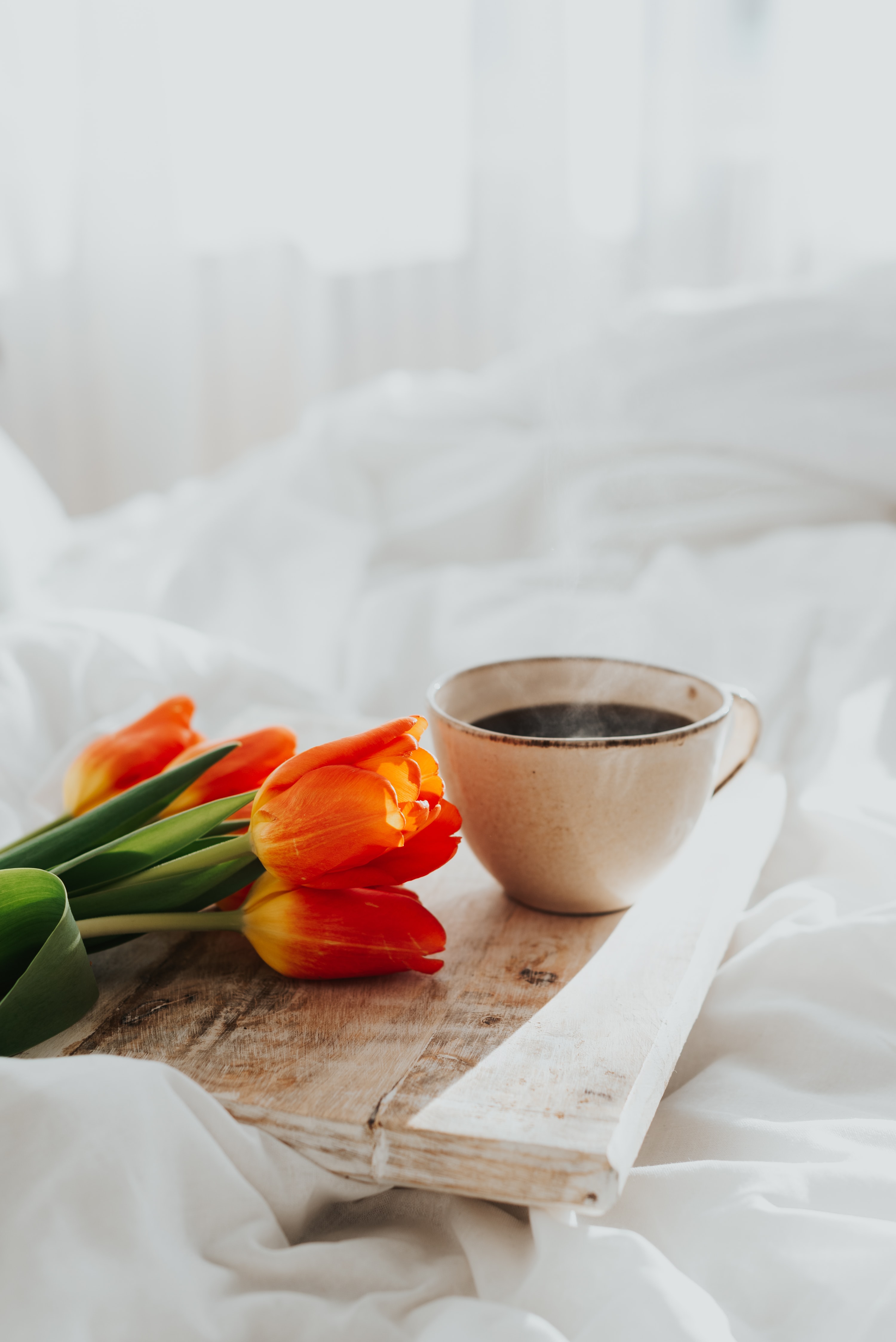 a cup of coffee and flowers on a tray