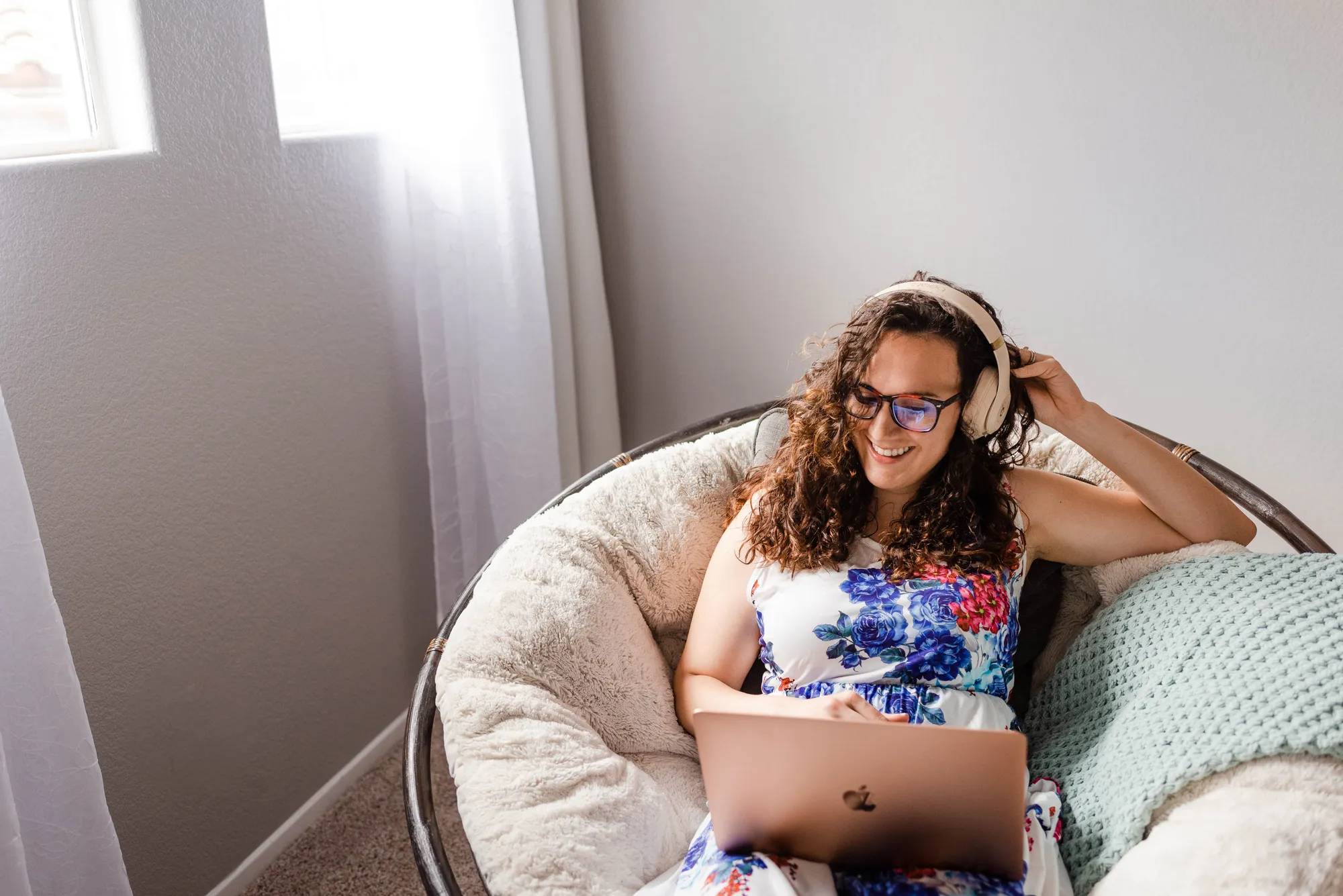 a woman sitting in a chair with a laptop