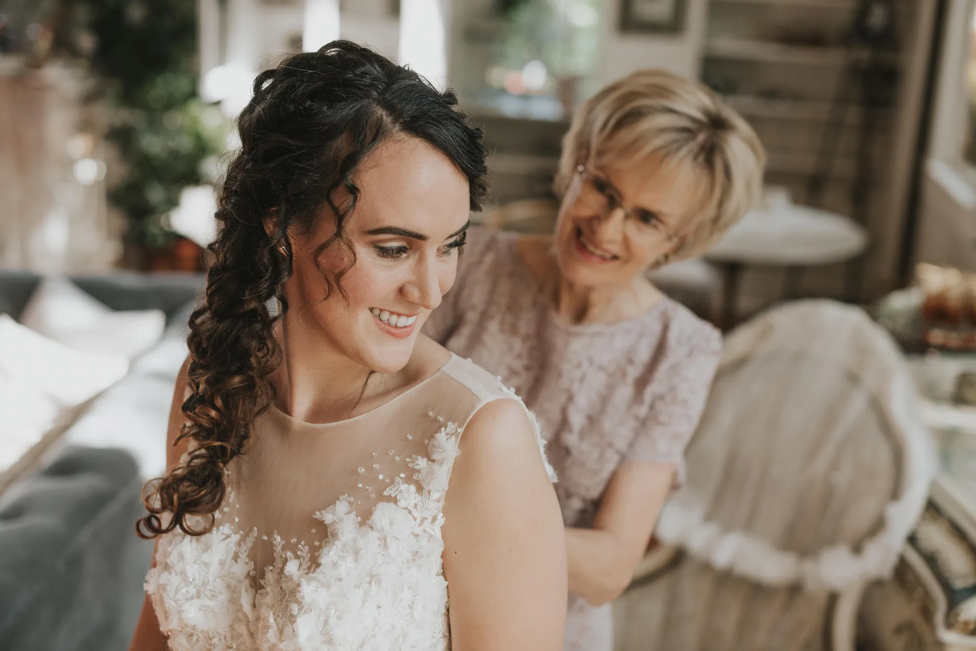 a woman in a dress smiling next to a woman in a room