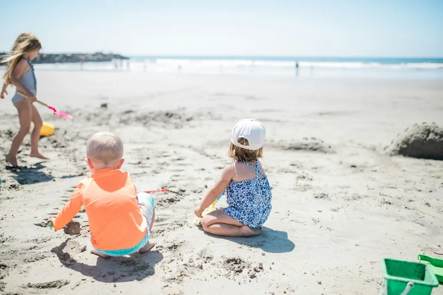 Two toddlers playing in the sand on a beach