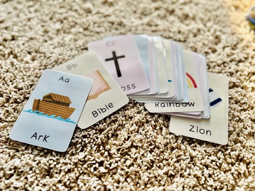 Bible flashcards for toddlers spread out on a rug