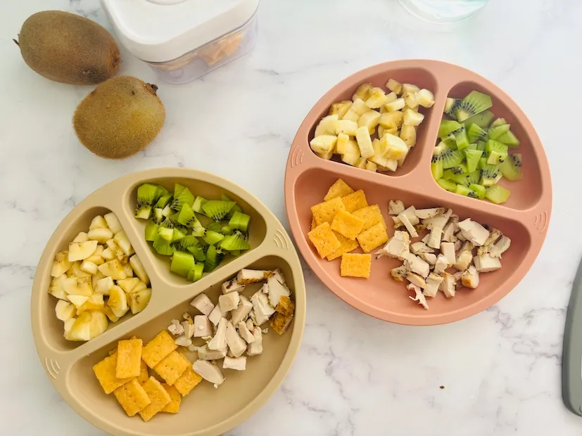 Toddler meal of fruit, vegetables and cheese on a divided plate