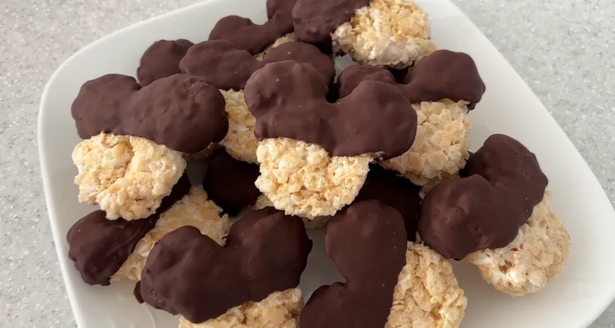 Chocolate-dipped Mickey Mouse rice crispy treats on a white plate