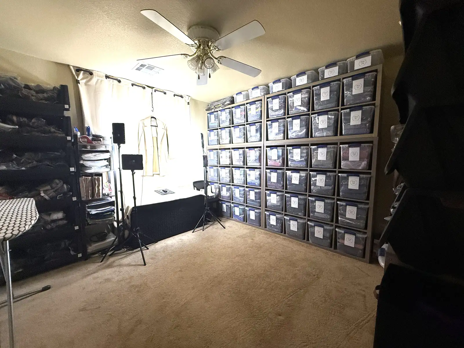 Giada's resale studio with a photo backdrop and floor-to-ceiling inventory bins