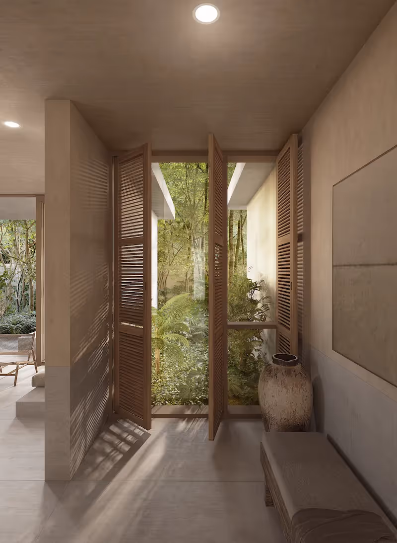 As you enter the condo, wooden blinds cast shade and frame the garden view - natural design typical of condos in Tulum
