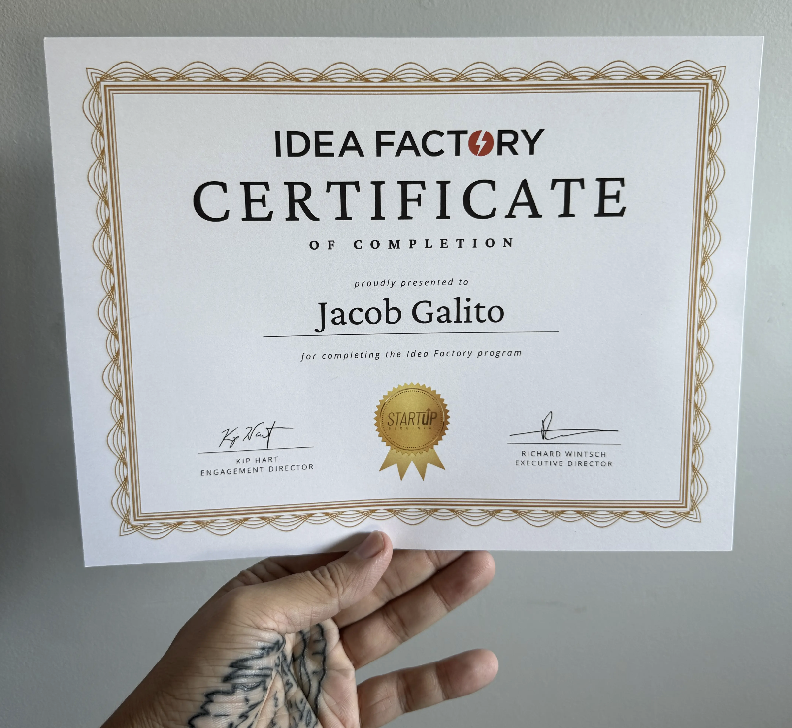 Photo of Jacob Galito holding his certificate of completion for StartUp VA's Idea Factory
