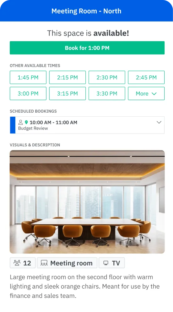 Large meeting room with a long table, orange chairs, warm lighting, and city view from tall windows.