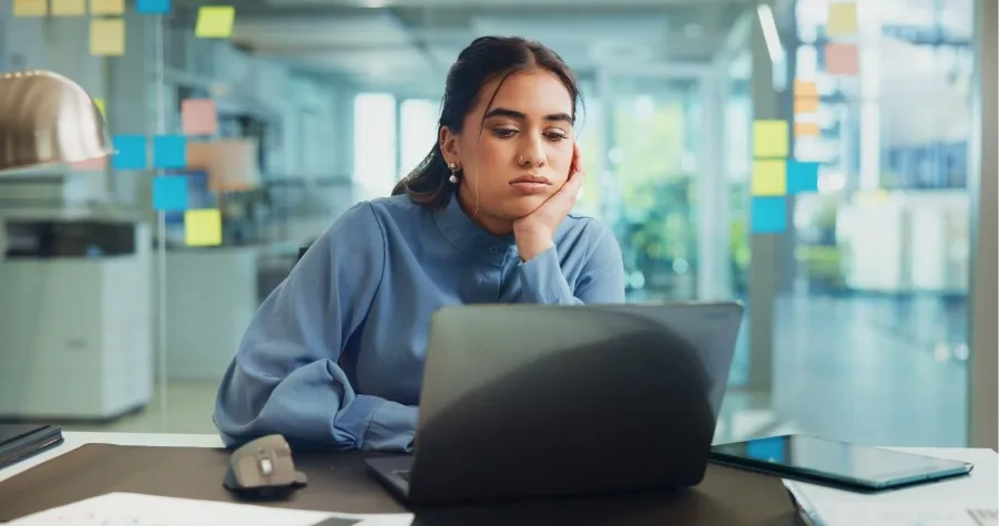 A person sitting at a desk looking at a computerAI-generated content may be incorrect.