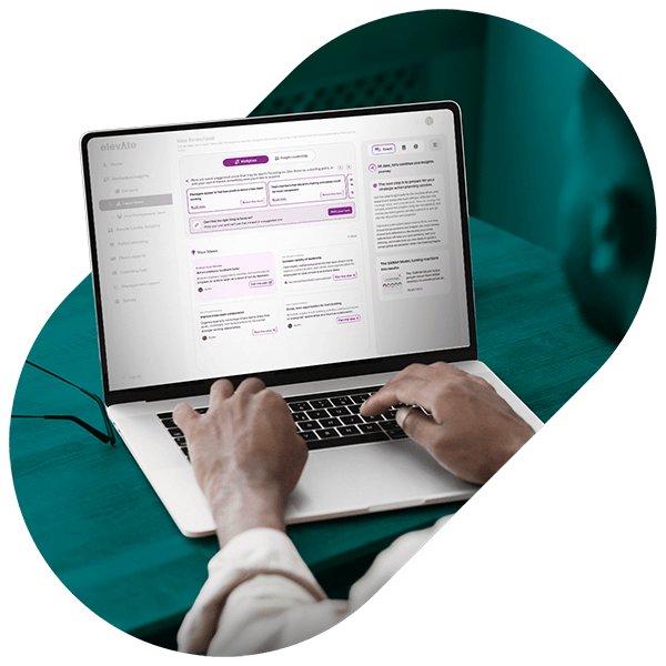 Person typing on a laptop showing a workforce insights dashboard on screen.