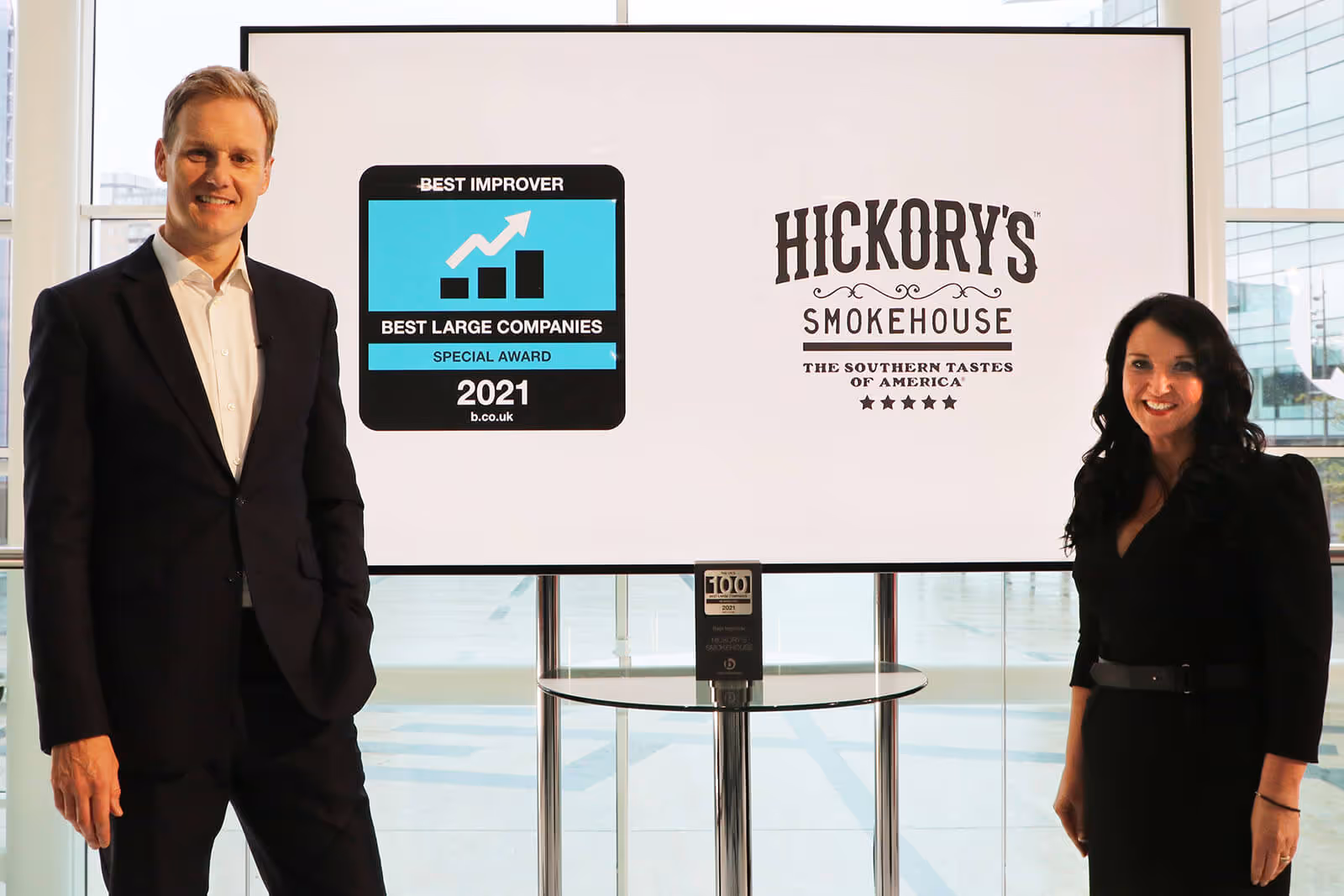 Presenter Dan Walker with the Head of People at Hickory's Smokehouse Racheal Woodcock as she receives the Best Improver Special Award at Best Companies Live