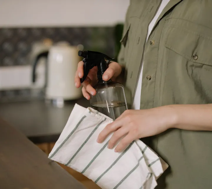 Cleaner wiping a kitchen benchtop