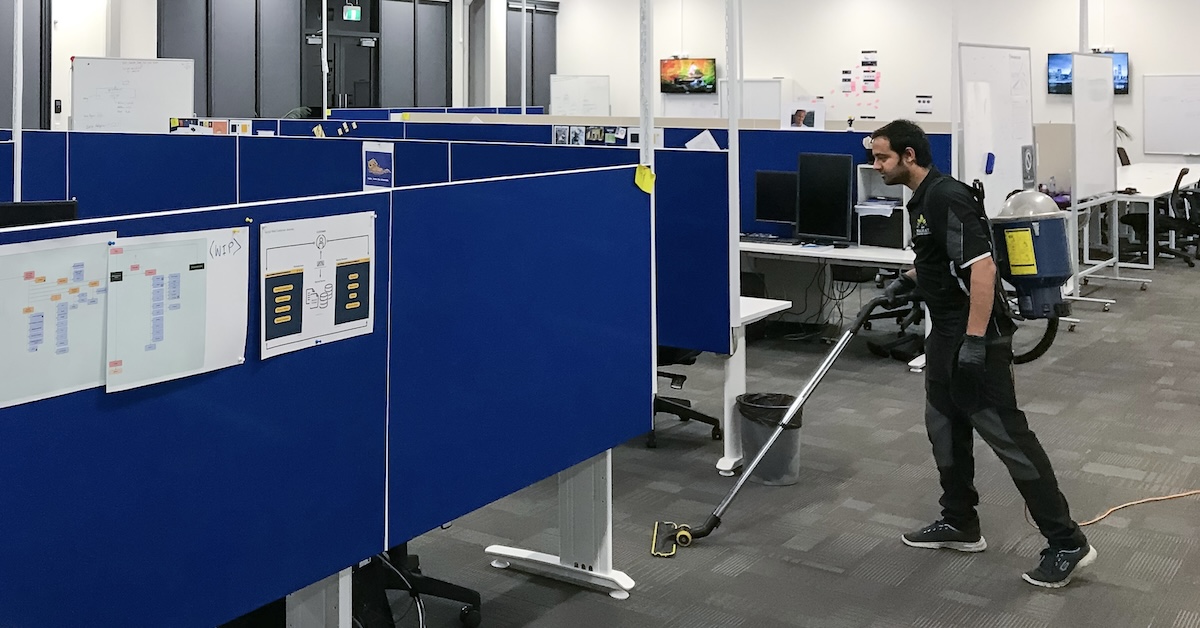 Professional cleaner vacuuming an office