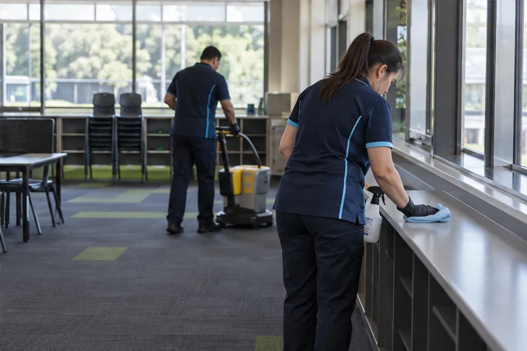 Cleaning team completing detailed work in an empty classroom