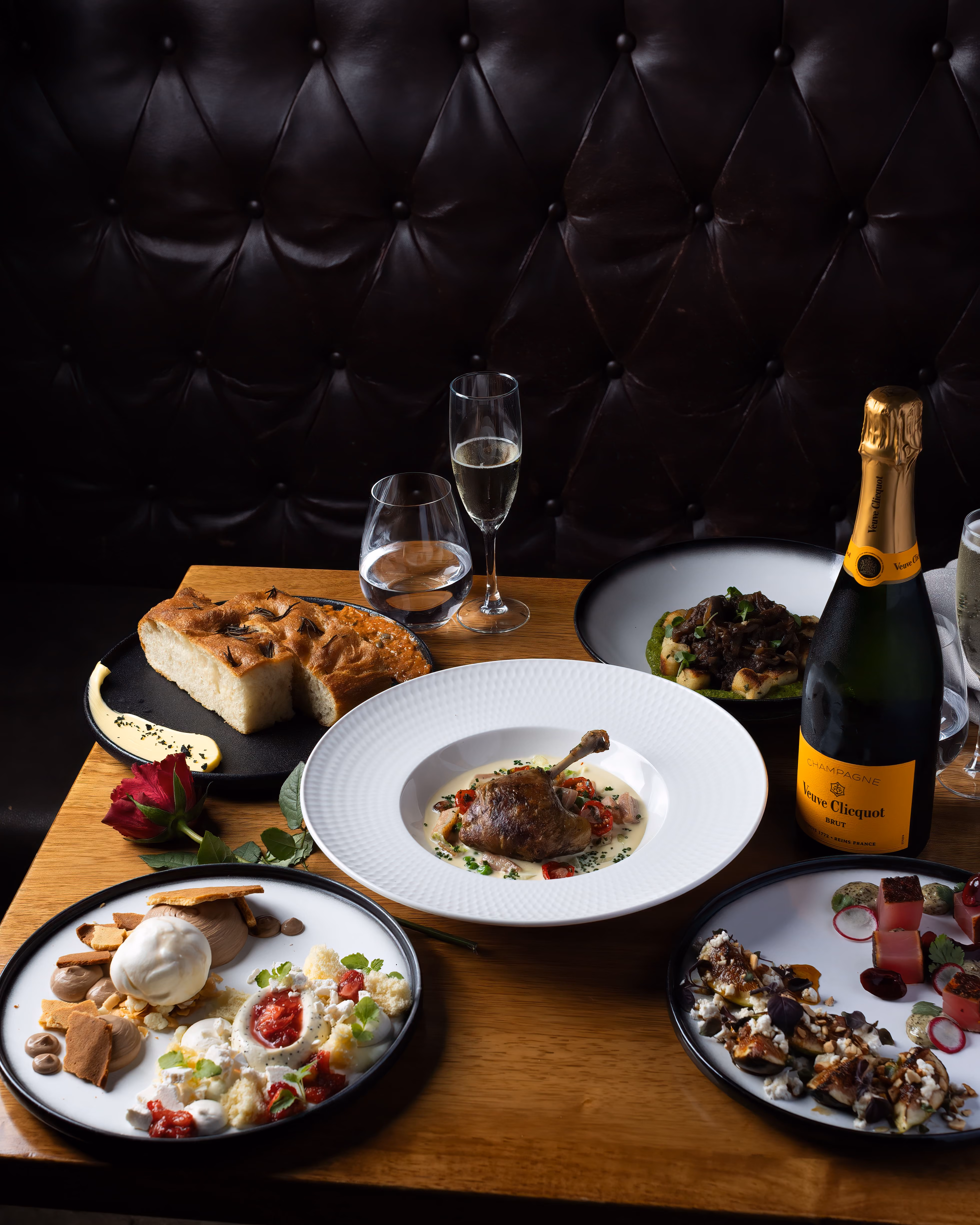 A spread of French and New Orleans dishes with champagne on the table at Orléans Restaurant & Bar, Maroochydore
