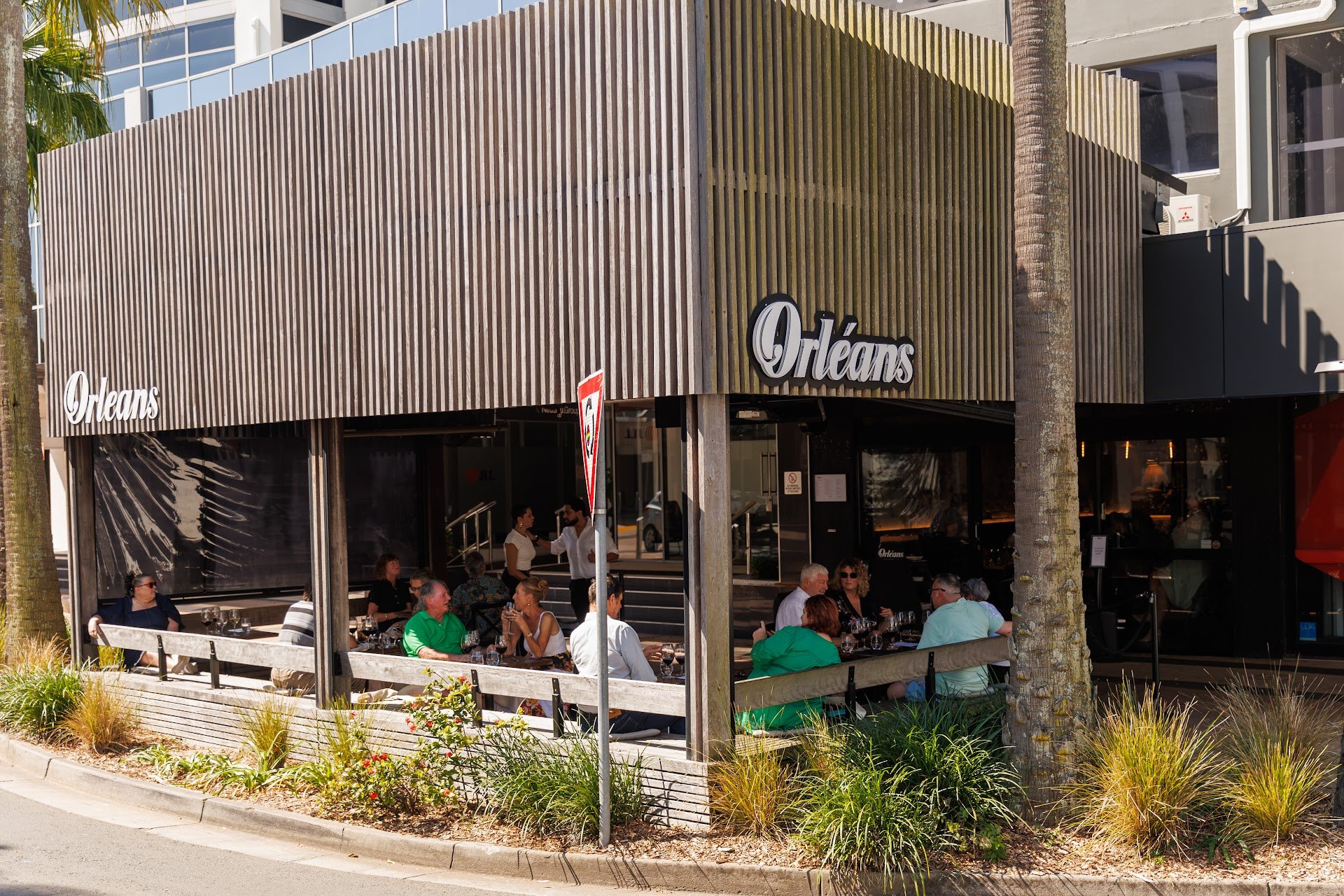 Street view of Orléans Restaurant & Bar's corner location on Duporth Ave, Maroochydore, with guests dining on the covered outdoor terrace
