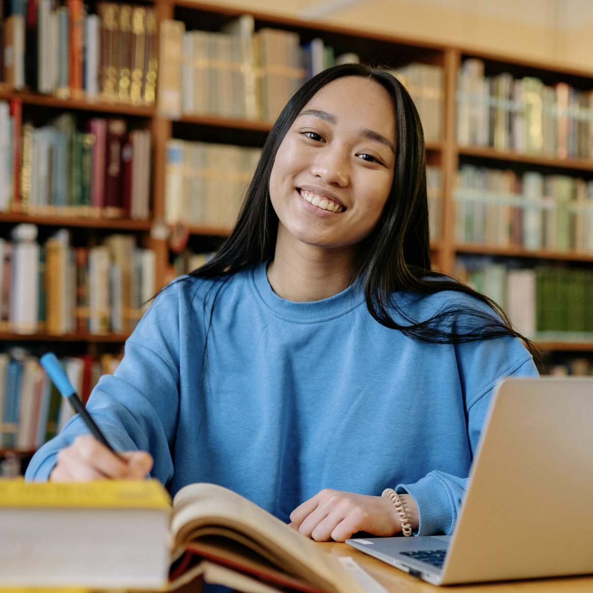 Female young adult smiling, studying at library