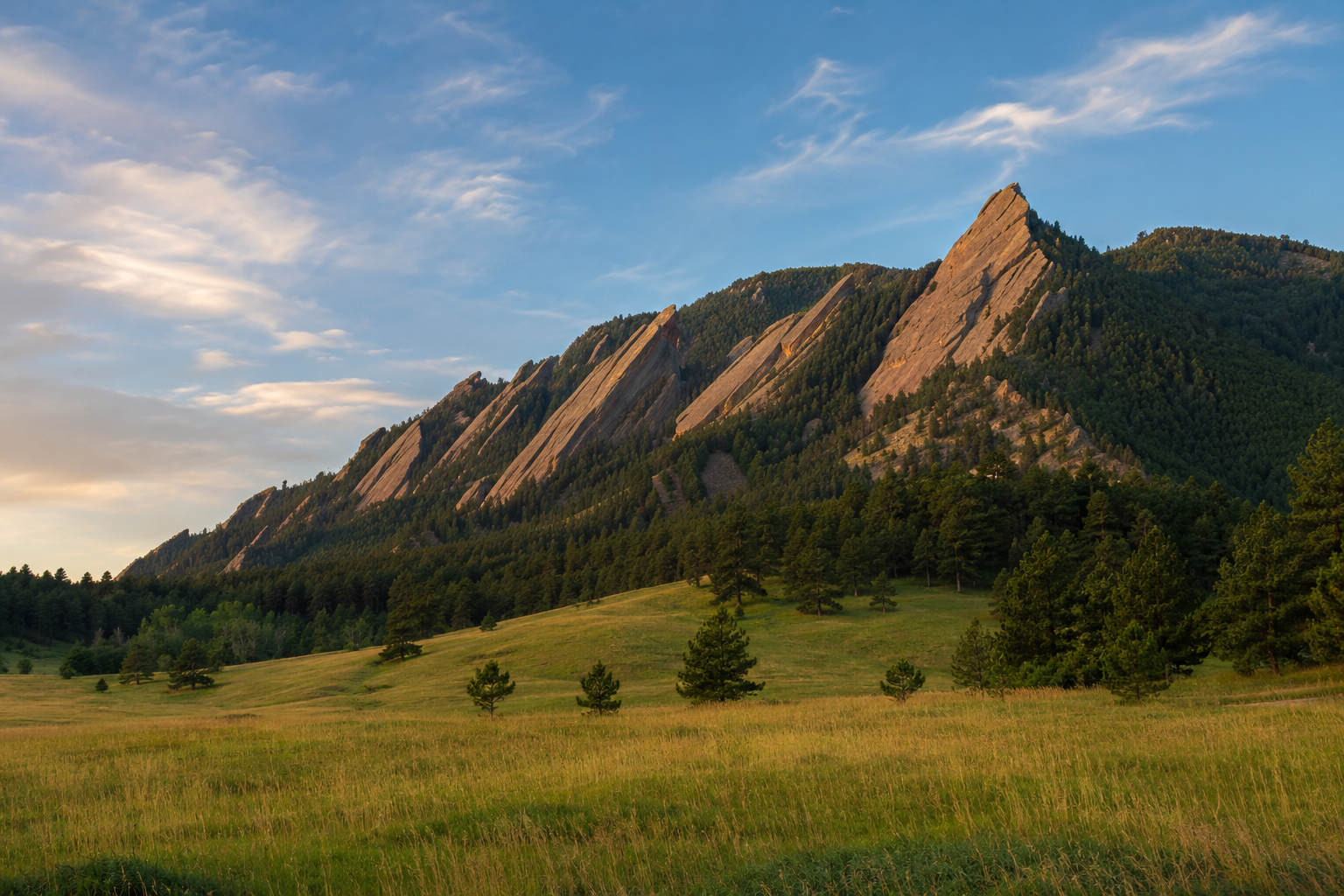 Colorado Flatirons rising above a green meadow near Boulder