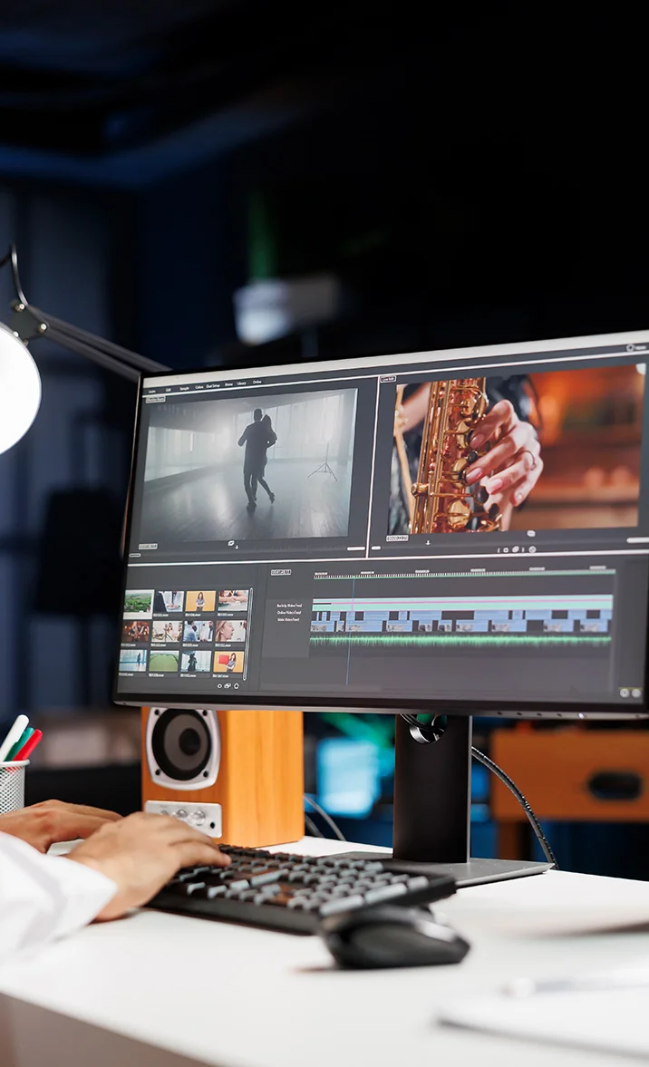 Person editing video footage on a desktop computer with clips showing a dancing silhouette and a close-up of a saxophone player.
