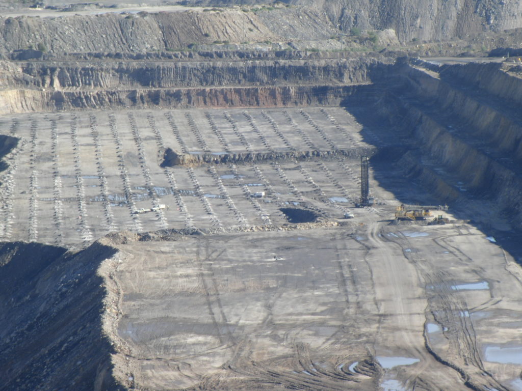 A drill a blast pattern at an open pit mine.