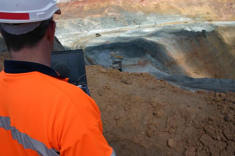 A mine worker observes current pit activity.