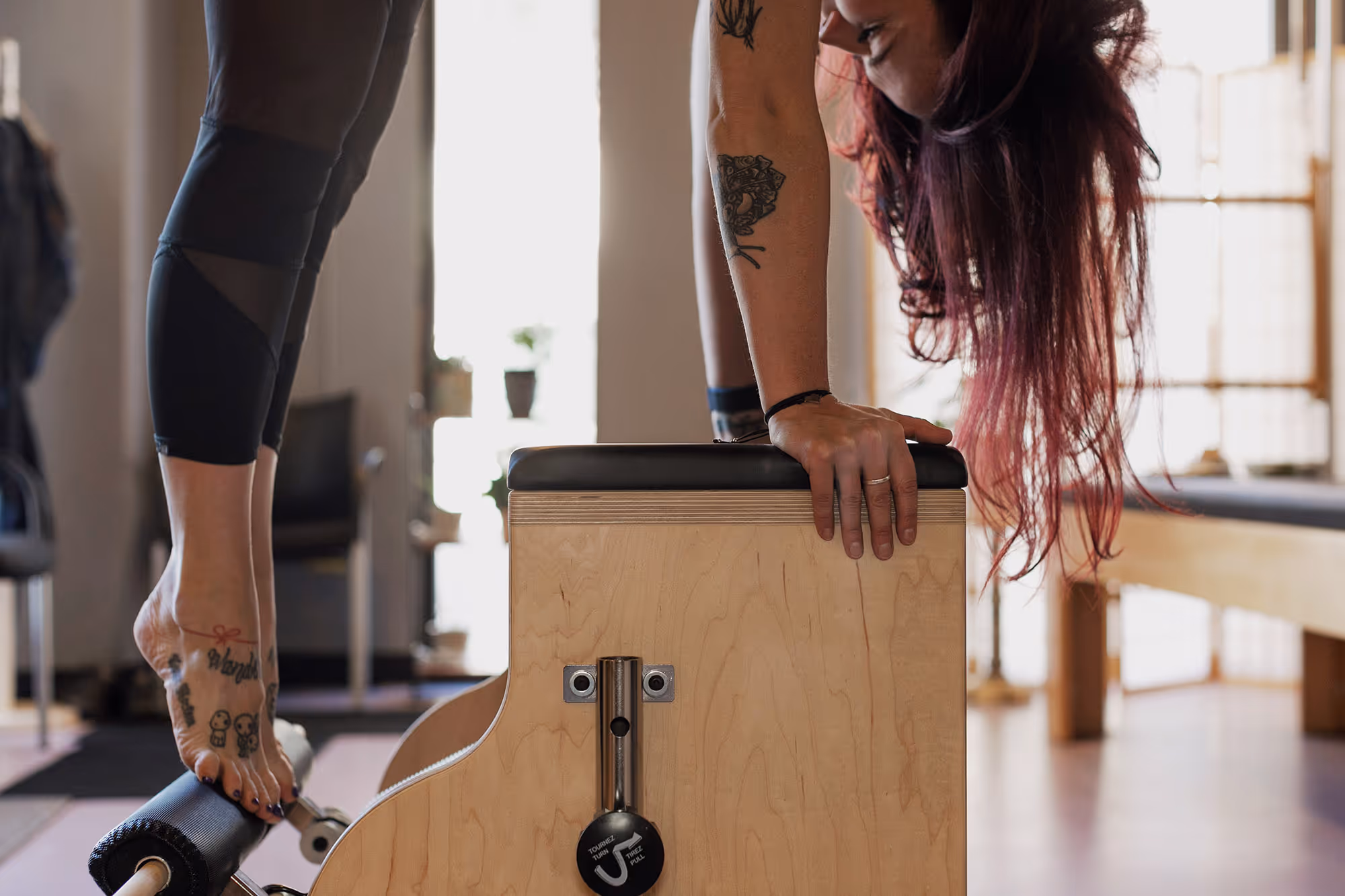 A closeup shot of Vanessa practicing Pilates on the Pilates Chair