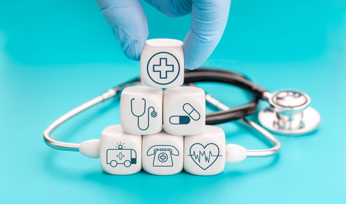 Blocks With Medical Icons on Them And a Stethoscope In The Background