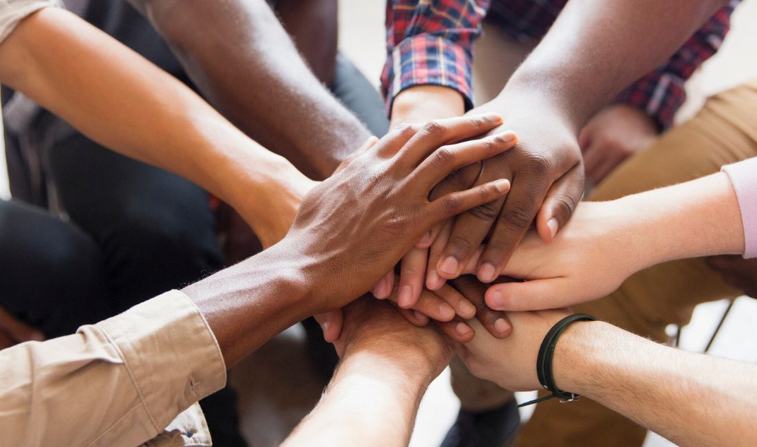 People Putting Their Hands Together in a Team Effort