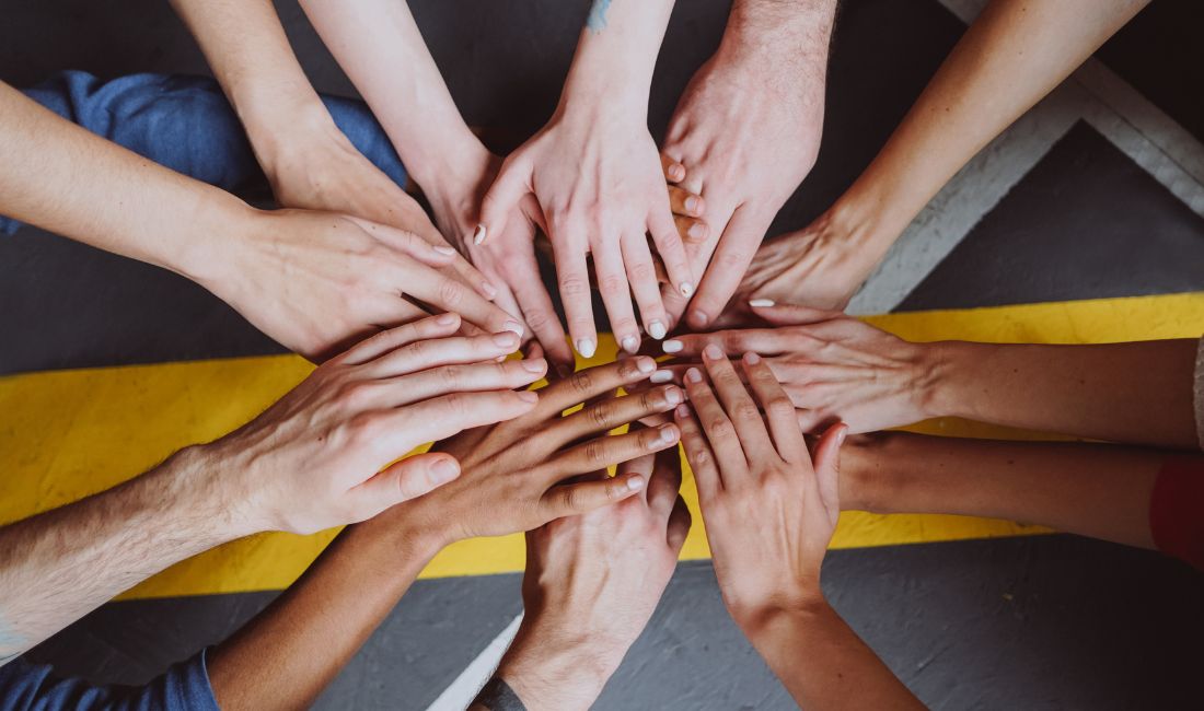people putting their hands in the middle together