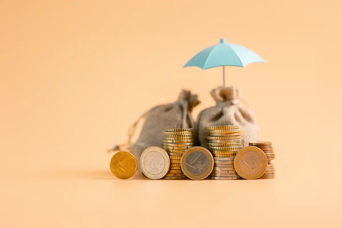 Um guarda-chuva sobre uma pilha de moedas.