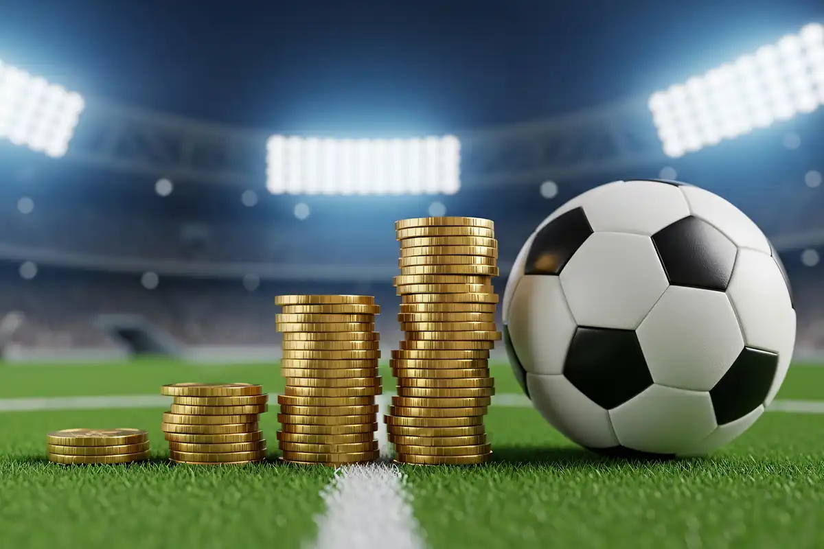 Pilhas de moedas e uma bola de futebol