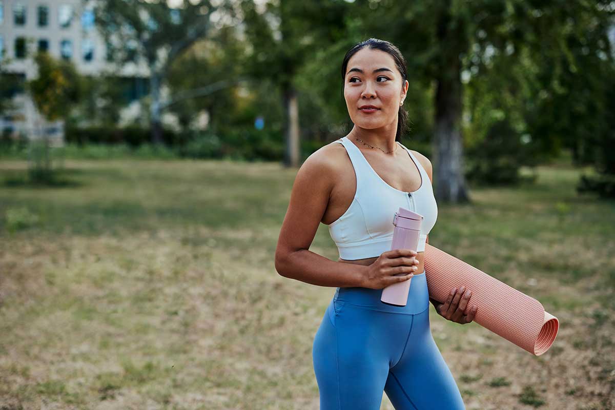 Imagem de uma mulher fazendo exercícios ao ar livre.
